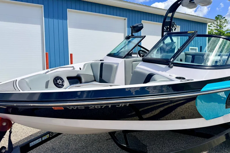 Slide: The Image of 2014 Nautique Super Air Nautique 210 boat parked near blue building. - 9