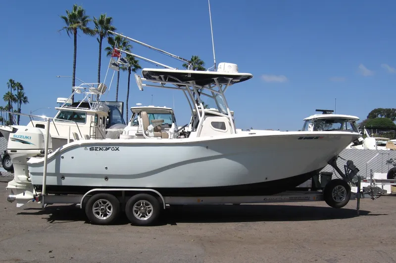 The Image of 2016 Sea Fox 266 Commander boat on trailer, parked with palm trees in background. - 0