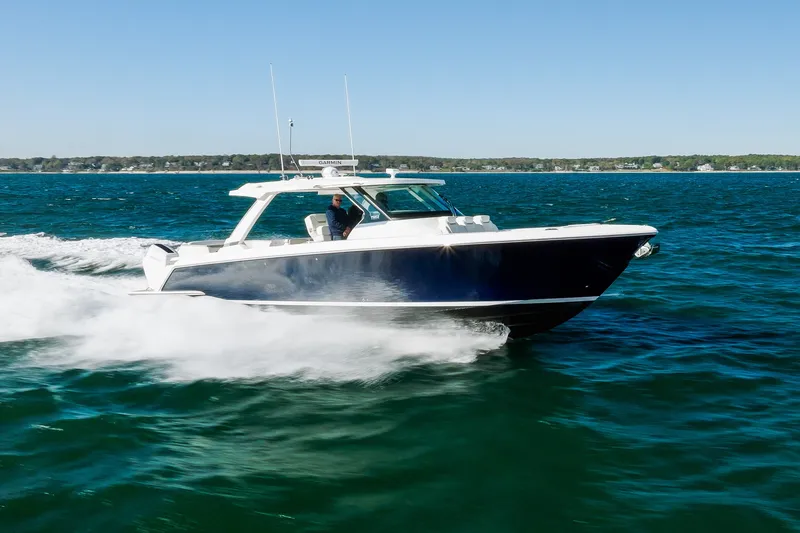 The Image of 2023 Tiara Yachts 43 LS cruising on open water under clear blue skies. - 2