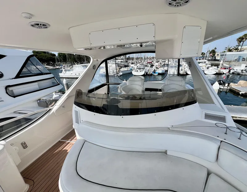 Slide: The Image of 2002 Sea Ray 560 Sedan Bridge yacht interior with marina view, featuring sleek seating and modern design. - 23