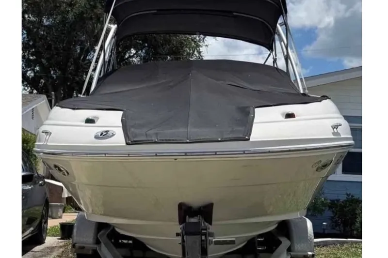 Slide: The Image of 2006 Sea Ray 220 Sundeck boat on trailer, covered and parked outdoors. - 9