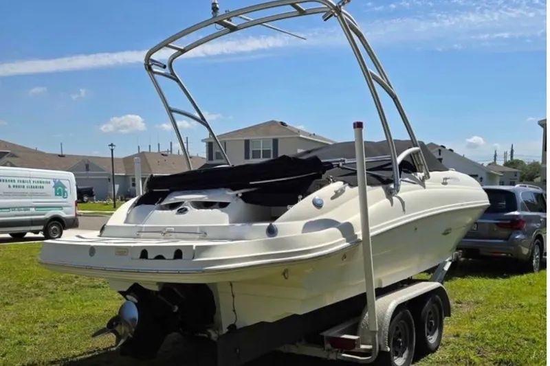 The Image of 2006 Sea Ray 220 Sundeck boat on trailer, parked in residential area. - 0