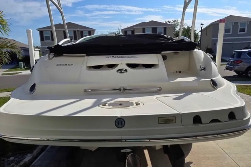 Slide: The Image of 2006 Sea Ray 220 Sundeck boat parked in a residential driveway. - 8