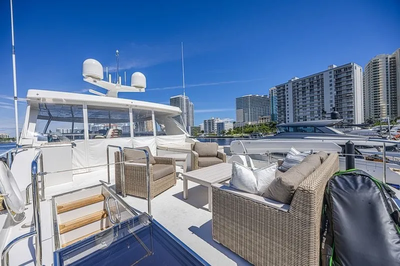 Slide: The Image of Luxurious 2018 Ocean Alexander 85 E yacht with elegant outdoor seating and cityscape backdrop. - 14