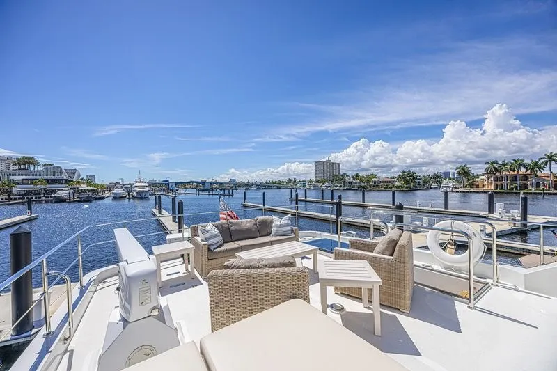 Slide: The Image of Luxurious 2018 Ocean Alexander 85 E yacht deck with elegant seating, overlooking marina. - 15