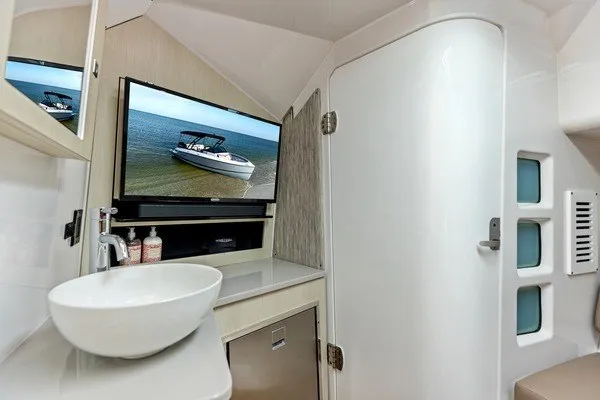 Slide: The Image of Interior of 2027 Monterey Elite 34 OB boat with modern bathroom and TV display. - 7