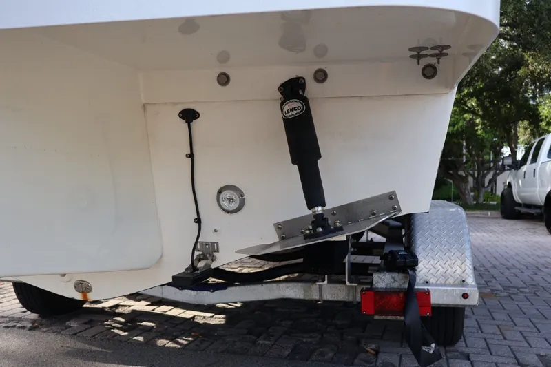 Slide: The Image of 1989 Mako 231 Center Console boat on trailer, rear view with trim tab and Lenco actuator. - 21