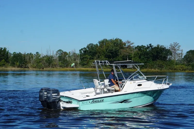 Slide: The Image of 2008 Angler 220WA boat with dual Yamaha engines on a calm lake. - 8