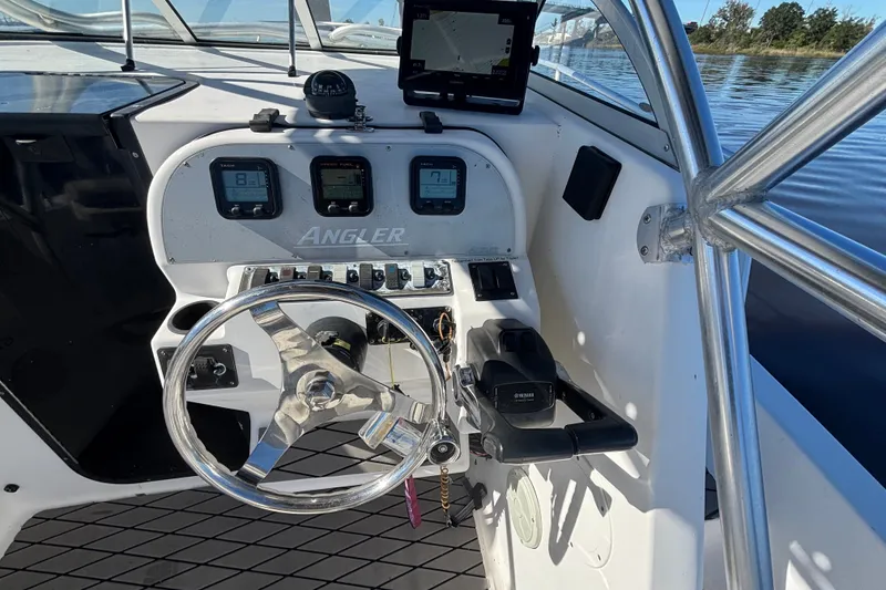 Slide: The Image of 2008 Angler 220WA boat dashboard with steering wheel and navigation instruments. - 14