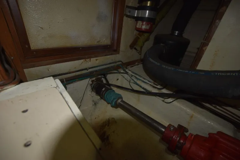 Slide: The Image of Engine compartment of 1985 Albin 43 Trawler, showing mechanical components and hoses. - 28