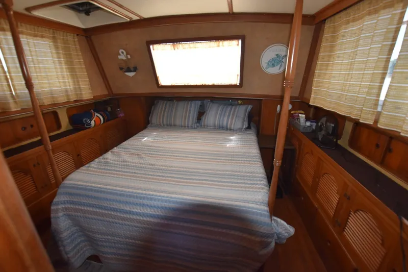 Slide: The Image of Cozy bedroom interior of 1985 Albin 43 Trawler with striped bedding and wooden cabinetry. - 18