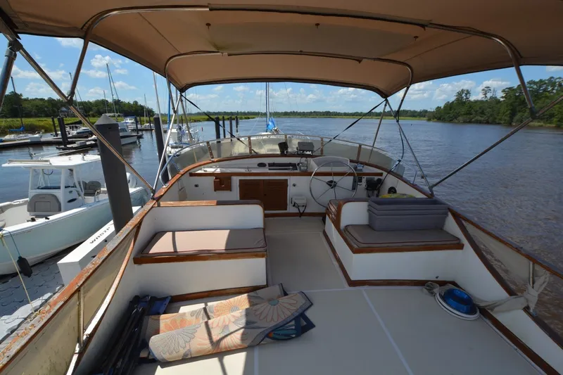 Slide: The Image of 1985 Albin 43 Trawler interior with seating, steering wheel, and river view. - 7