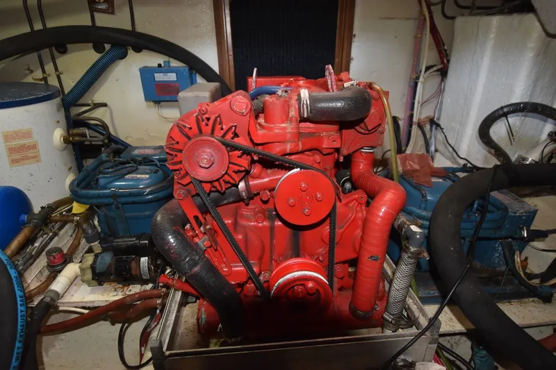 Slide: The Image of Engine room of 1985 Albin 43 Trawler with red engine components and surrounding equipment. - 27