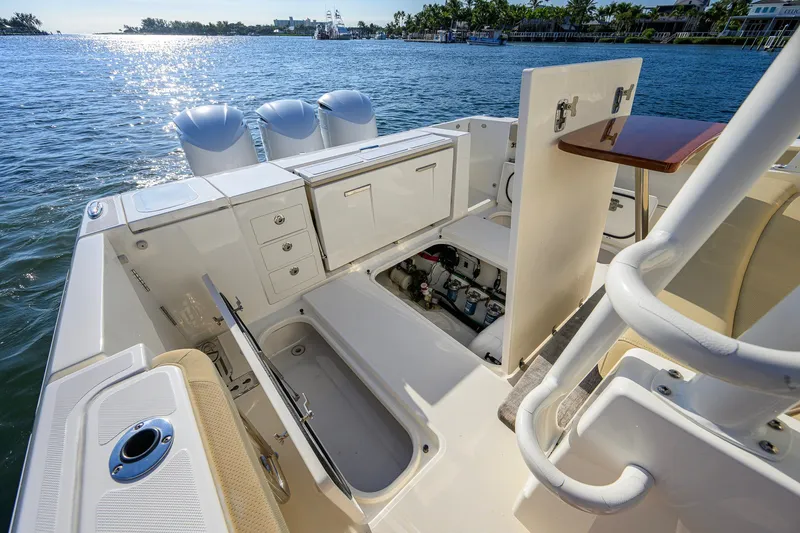 Slide: The Image of 2020 Pursuit S 368 Sport boat interior with open storage compartments and ocean view. - 26