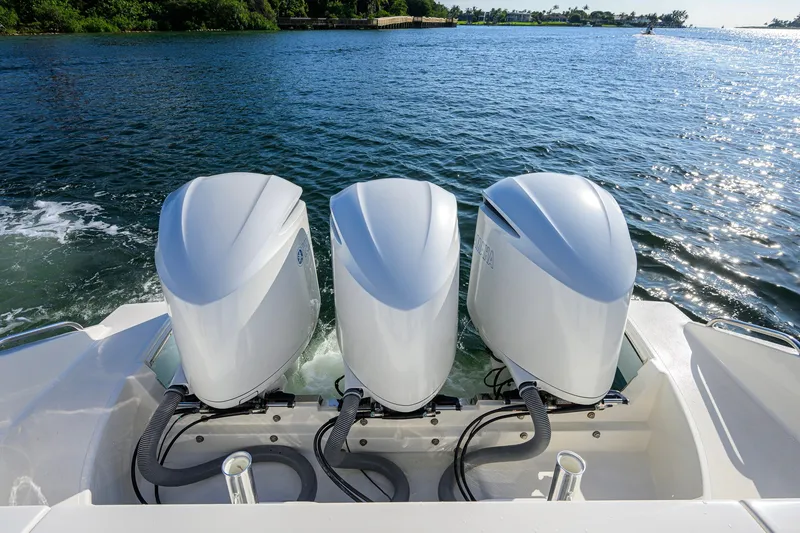 Slide: The Image of Triple outboard motors on a 2020 Pursuit S 368 Sport boat, cruising on a sunny lake. - 35