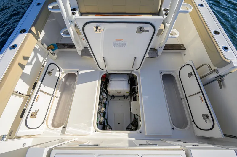 Slide: The Image of 2020 Pursuit S 368 Sport boat deck with open storage compartments and engine access. - 27