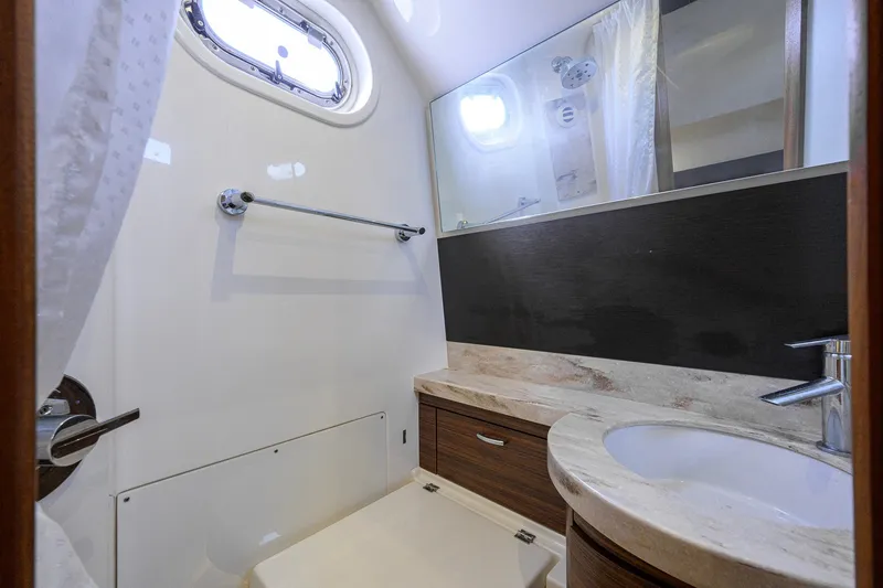 Slide: The Image of 2020 Pursuit S 368 Sport boat bathroom with modern sink and porthole window. - 36