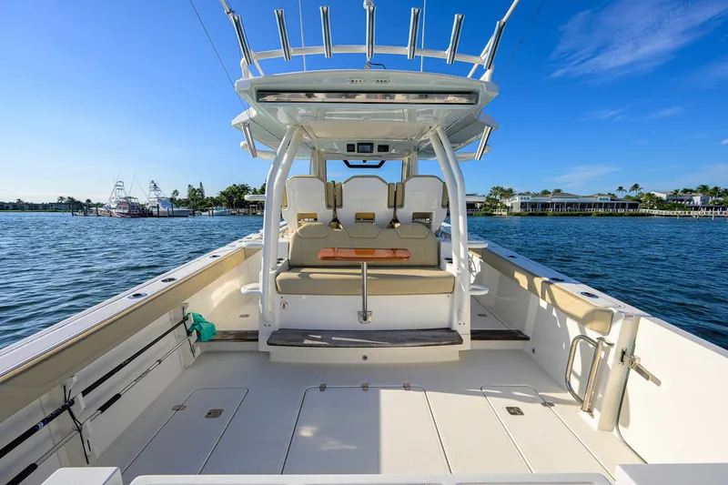 Slide: The Image of 2020 Pursuit S 368 Sport boat interior with seating, on a sunny day by the water. - 23
