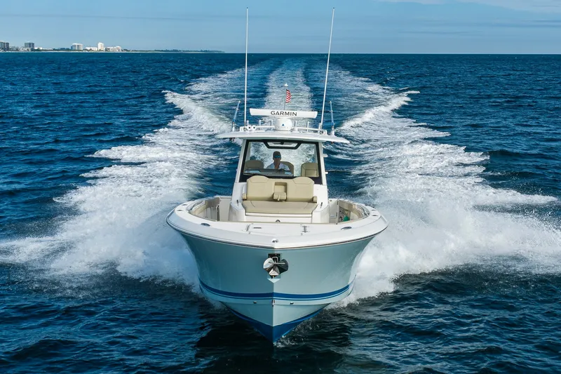 Slide: The Image of 2020 Pursuit S 368 Sport boat cruising on open water, leaving a wake behind. - 43