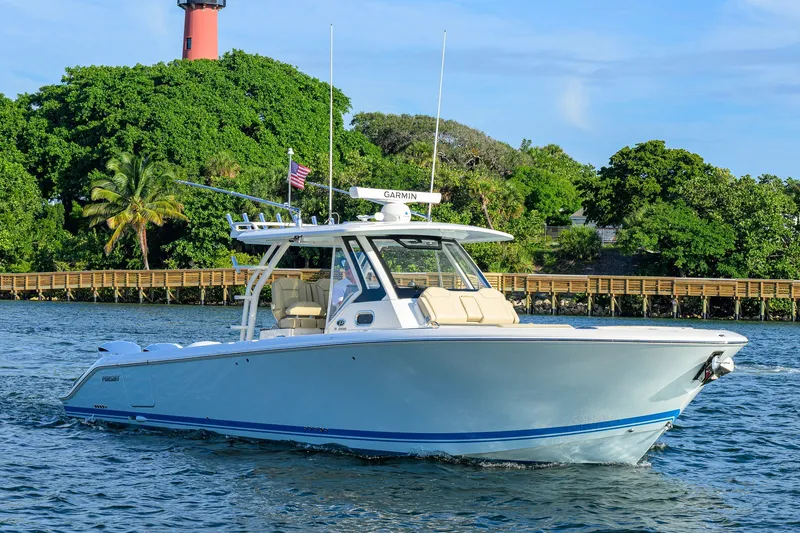 Slide: The Image of 2020 Pursuit S 368 Sport boat cruising near lush green shoreline. - 39