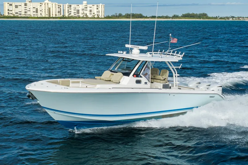 Slide: The Image of 2020 Pursuit S 368 Sport boat cruising on ocean near coastal buildings. - 42