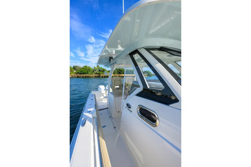 Slide: The Image of 2020 Pursuit S 368 Sport boat on water, showcasing sleek design and spacious deck. - 38