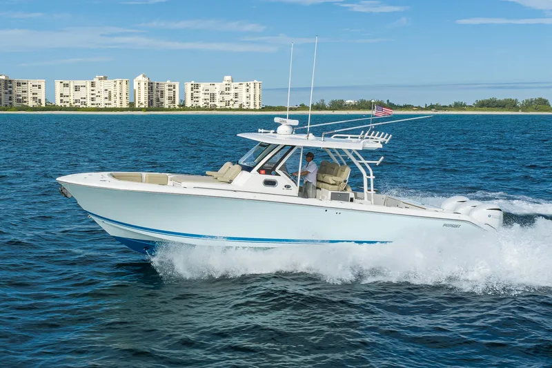 Slide: The Image of 2020 Pursuit S 368 Sport boat cruising on ocean near coastal buildings. - 41