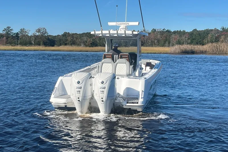 Slide: The Image of 2025 Everglades 315 Center Console boat with twin 350 V6 engines on a calm lake. - 5