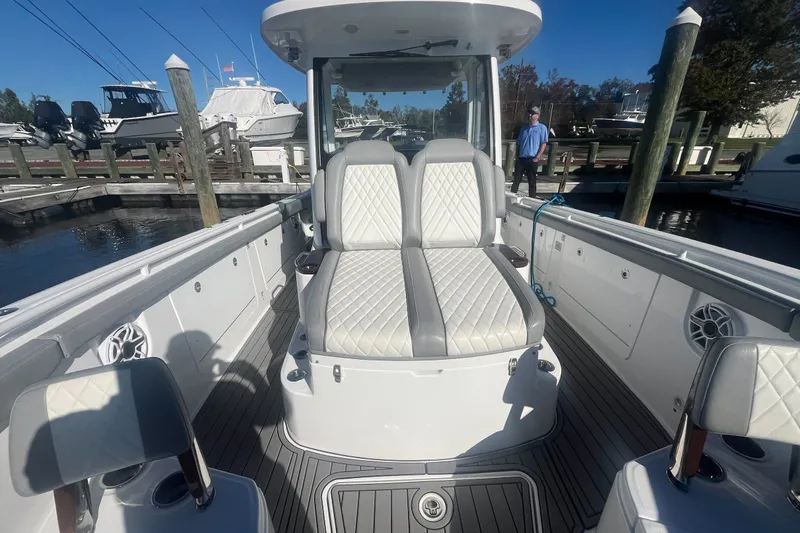 Slide: The Image of 2025 Everglades 315 Center Console boat with luxurious seating at a marina. - 8
