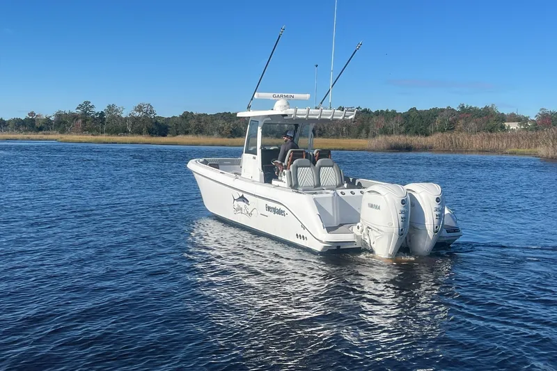 Slide: The Image of 2025 Everglades 315 Center Console boat on calm water, featuring twin Yamaha engines. - 3