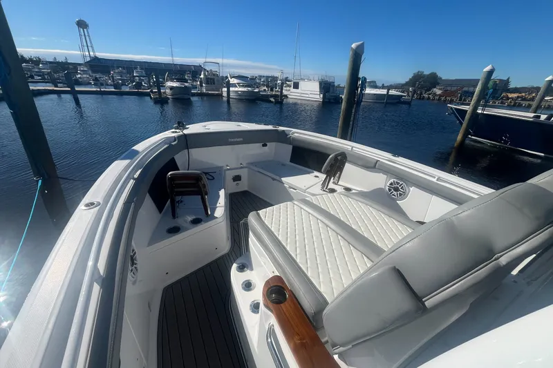 Slide: The Image of 2025 Everglades 315 Center Console boat docked at marina under clear blue sky. - 9