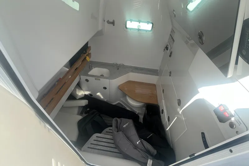 Slide: The Image of Interior cabin of 2025 Everglades 315 Center Console boat, featuring compact amenities. - 14
