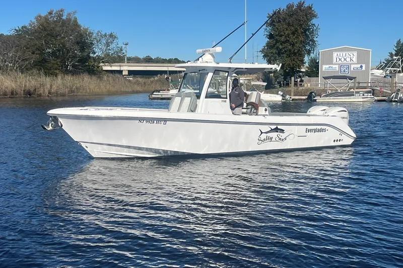 Slide: The Image of 2025 Everglades 315 Center Console boat on water near dock, clear day. - 1