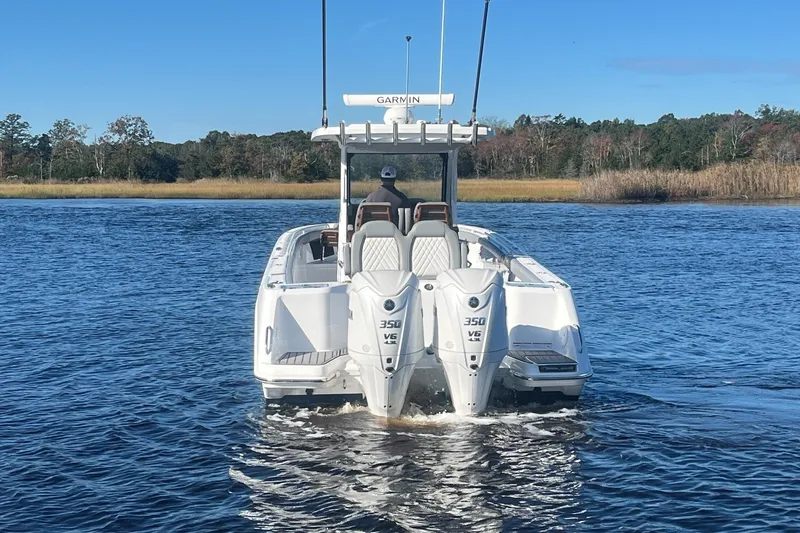 Slide: The Image of 2025 Everglades 315 Center Console boat with dual engines on a serene lake. - 4