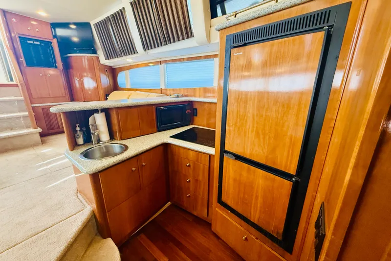 Slide: The Image of Interior of 2001 Carver 444 Cockpit Motor Yacht with kitchenette and wood cabinetry. - 18