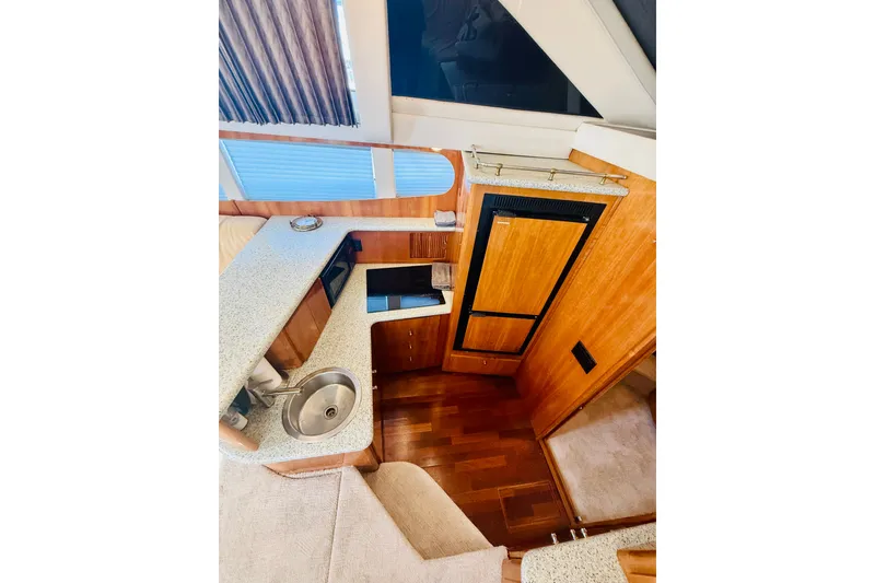Slide: The Image of Interior of 2001 Carver 444 Cockpit Motor Yacht with kitchenette and wood finishes. - 17