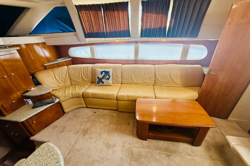 Slide: The Image of Interior of 2001 Carver 444 Cockpit Motor Yacht with beige leather seating and wooden table. - 15