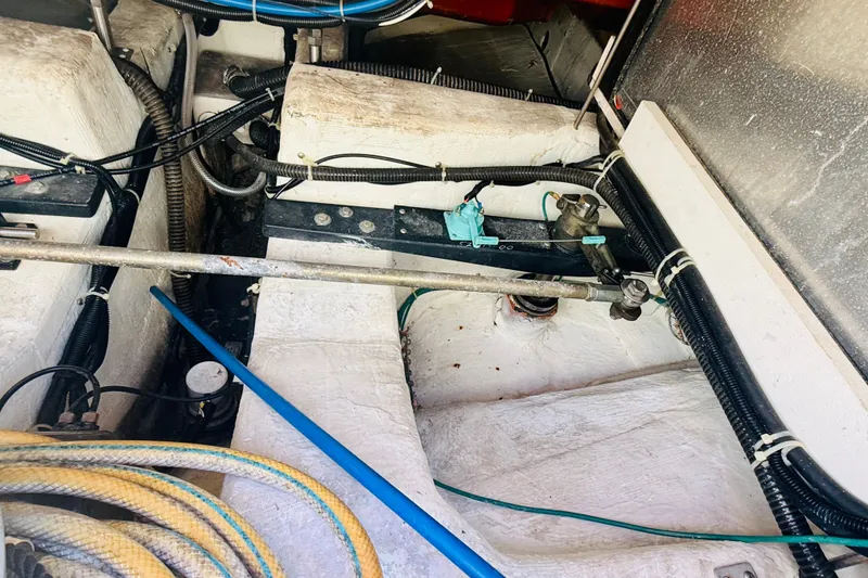 Slide: The Image of Engine compartment of a 2001 Carver 444 Cockpit Motor Yacht with visible wiring and hoses. - 25