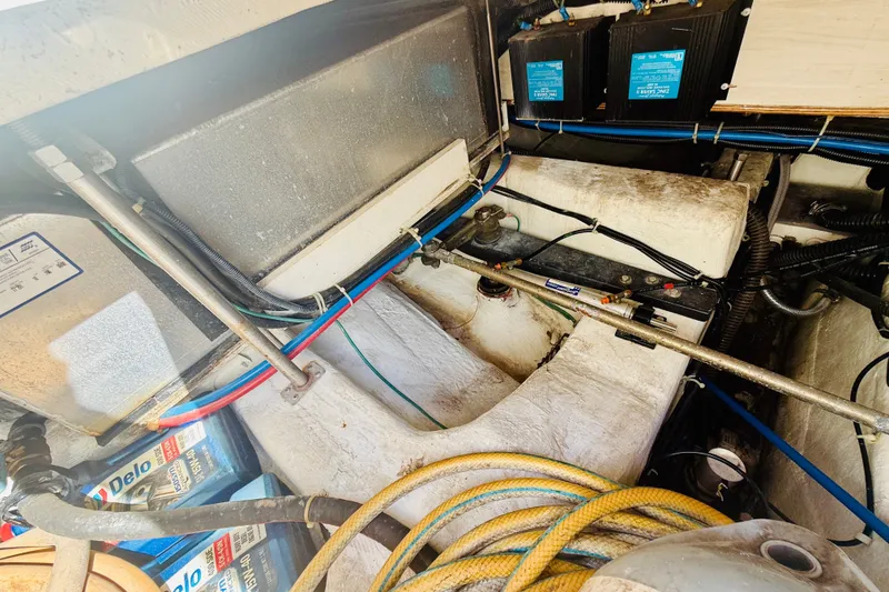 Slide: The Image of Engine compartment of a 2001 Carver 444 Cockpit Motor Yacht with visible wiring and components. - 23