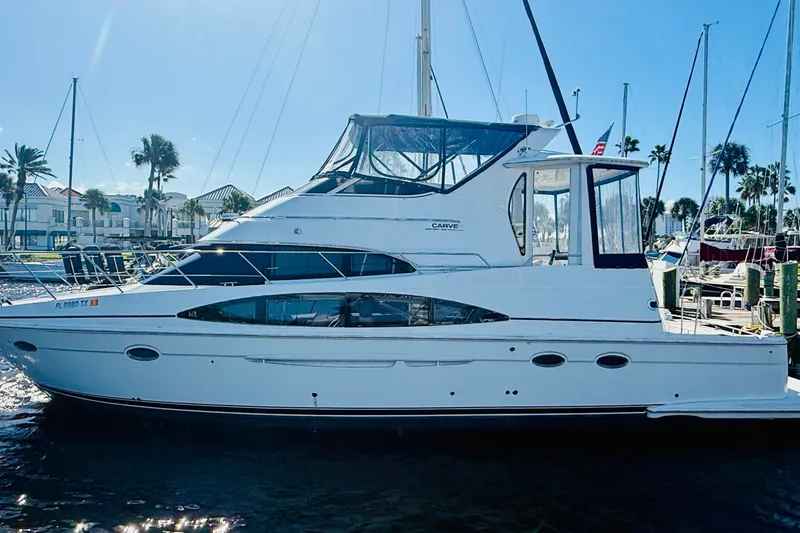 The Image of 2001 Carver 444 Cockpit Motor Yacht docked in a sunny marina setting. - 0