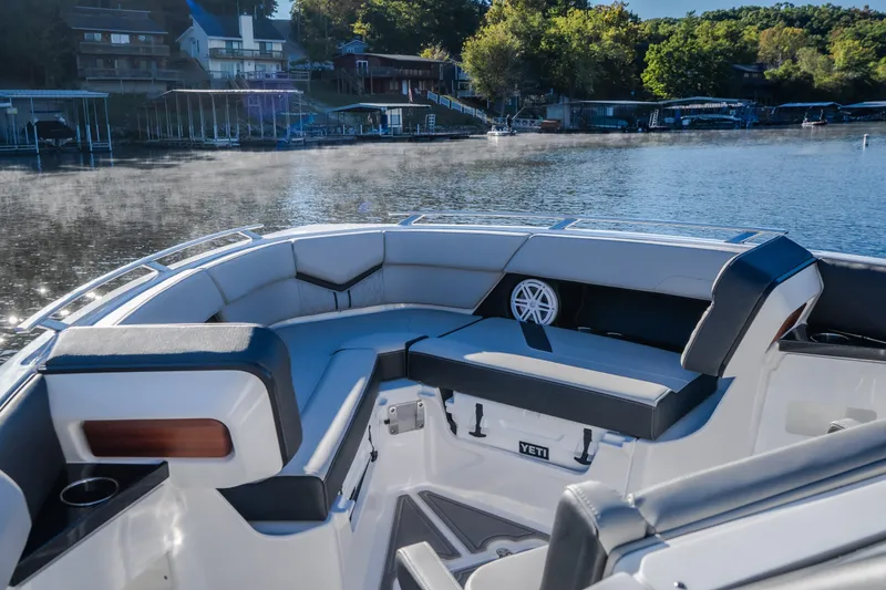 Slide: The Image of Luxurious seating on 2026 Monterey Elite 30 OB boat, docked by a serene lakeside. - 58