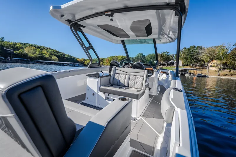 Slide: The Image of 2026 Monterey Elite 30 OB boat interior with luxurious seating on a scenic lake. - 10