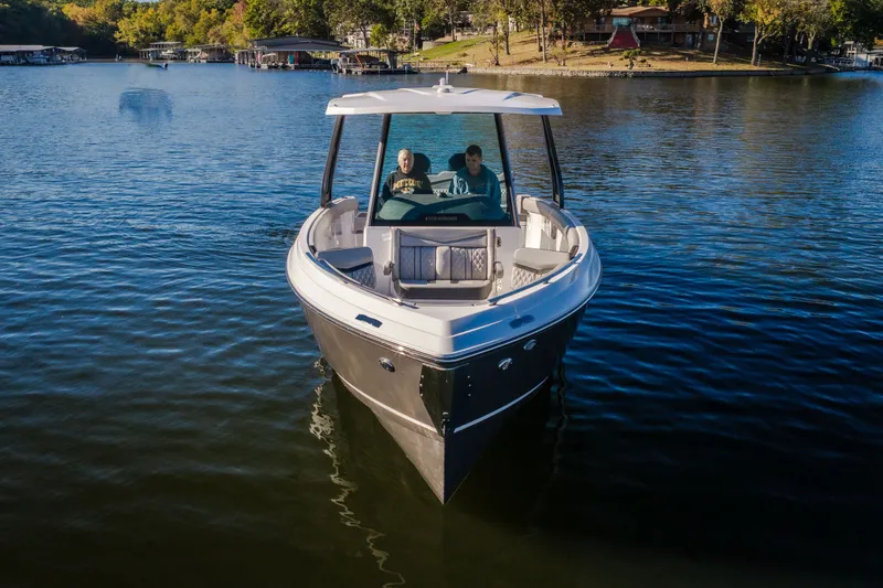 Slide: The Image of 2026 Monterey Elite 30 OB boat cruising on a serene lake with two passengers. - 3