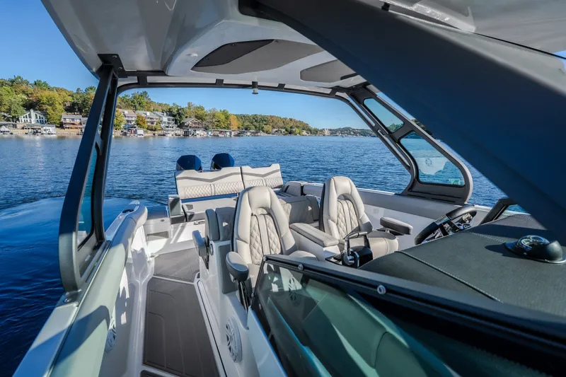 Slide: The Image of 2026 Monterey Elite 30 OB boat interior with luxurious seating on a scenic lake. - 59