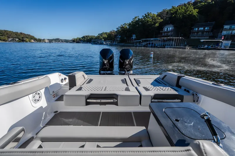 Slide: The Image of 2026 Monterey Elite 30 OB boat interior with dual engines on a scenic lake. - 32