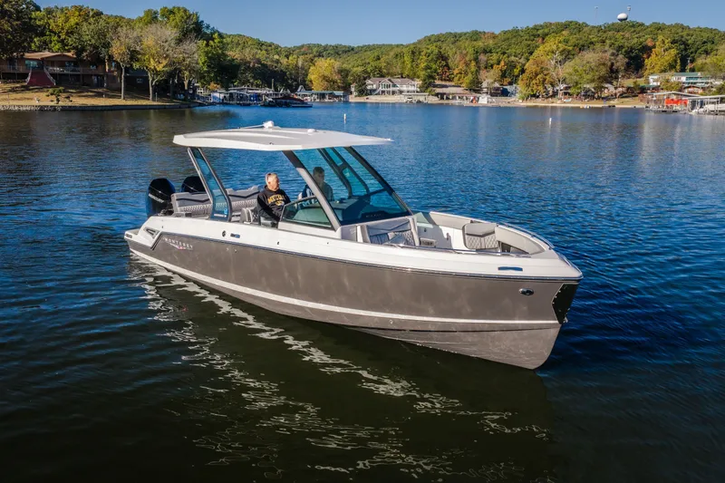 Slide: The Image of 2026 Monterey Elite 30 OB boat cruising on a scenic lake. - 2