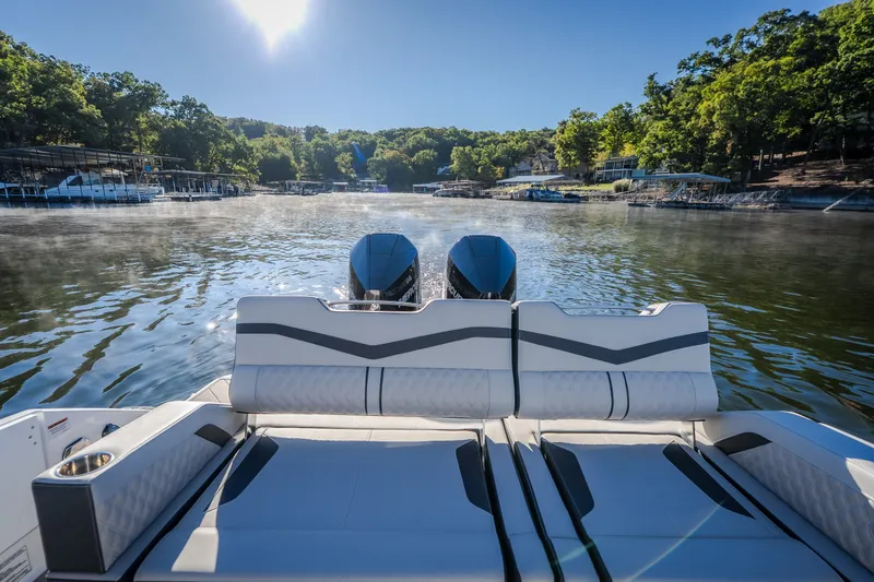 Slide: The Image of 2026 Monterey Elite 30 OB boat on a serene lake with lush green surroundings. - 30