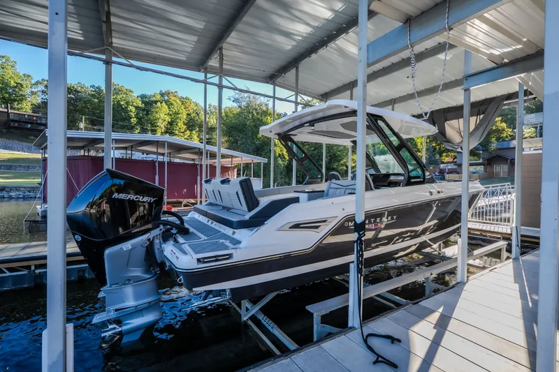 Slide: The Image of 2026 Monterey Elite 30 OB boat docked under a covered marina. - 78