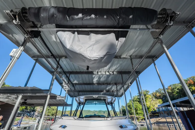 Slide: The Image of 2026 Monterey Elite 30 OB boat docked under covered marina with clear blue sky. - 76