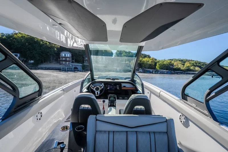Slide: The Image of Interior view of 2026 Monterey Elite 30 OB boat with scenic waterfront backdrop. - 13